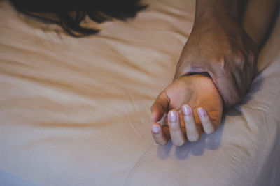 Cropped image of couple doing sex on bed at home