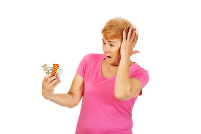Woman holding pink face against white background