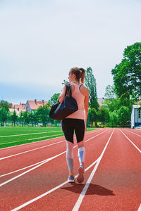 Woman going on fitness training with sport bag