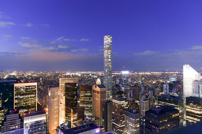 Illuminated buildings in city against sky