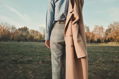 Low section of woman standing on field