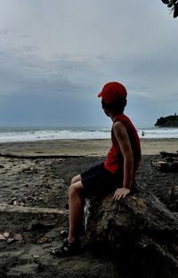 Boy looking at sea against sky