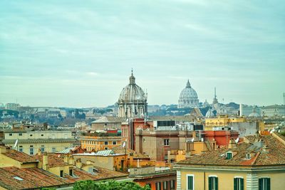 St peters basilica amidst buildings in city against sky