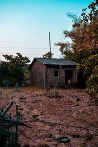 Abandoned house on field against clear sky