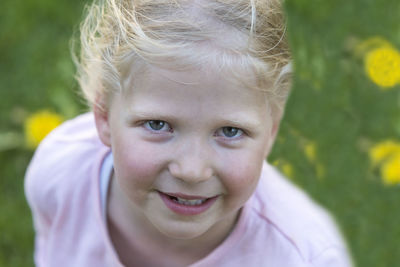 High angle portrait of smiling girl standing on field at park