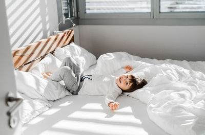 High angle view of boy lying down on floor at home