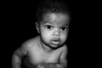 Portrait of cute baby girl against black background