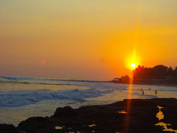 Scenic view of beach against clear sky during sunset