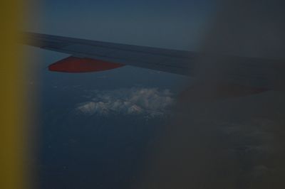 Airplane wing against sky during sunset