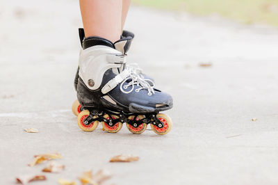 Low section of person inline skating on road