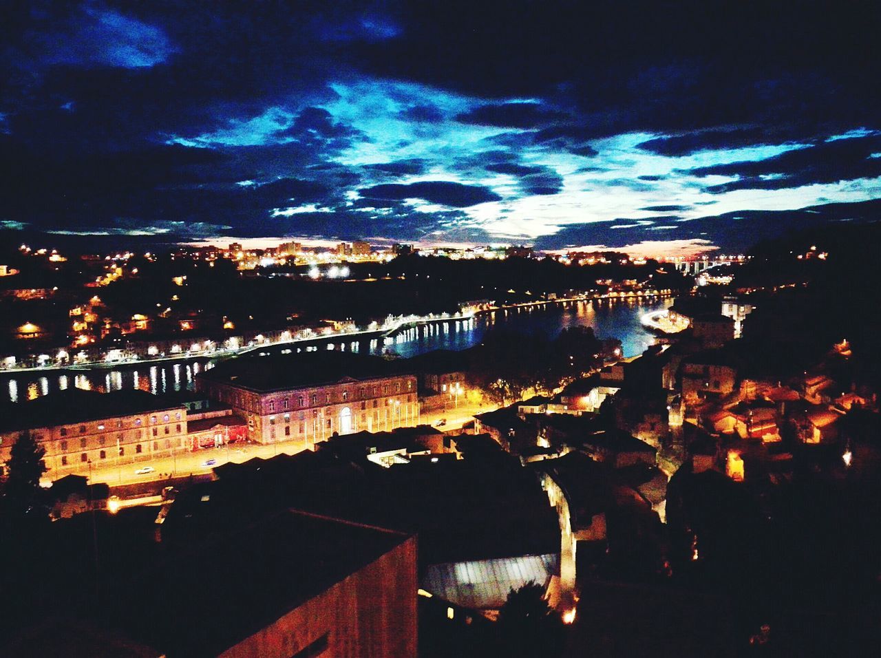 illuminated, night, architecture, built structure, building exterior, sky, city, cityscape, water, river, cloud - sky, high angle view, dusk, residential building, residential district, residential structure, outdoors, city life, no people, reflection