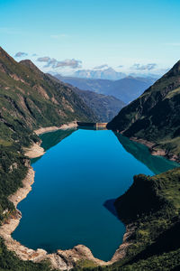 High angle view of lake and mountains against blue sky