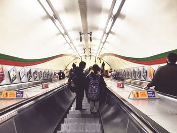 Rear view of people on escalator at subway station