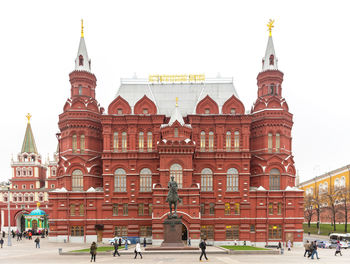 Group of people in front of building against clear sky