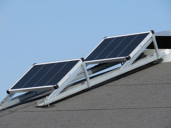 Low angle view of traditional windmill against clear blue sky