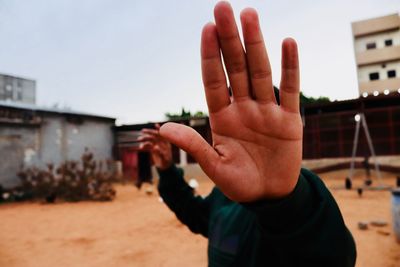 Midsection of man with arms raised against sky