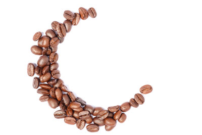 High angle view of coffee beans against white background