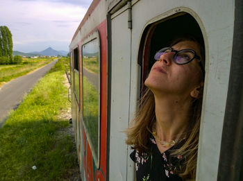 Woman looking through window from train