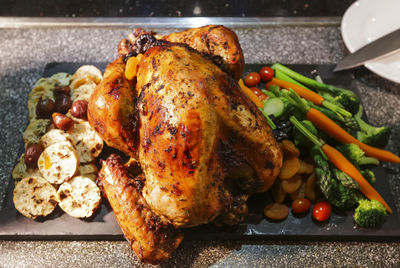 Close-up of roasted chicken on slate