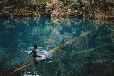 A boy who stand in the middle of the lake