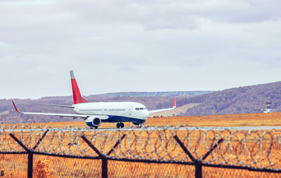 Civilian passenger plane accelerates along the runway on the airport field