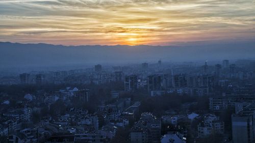 Aerial view of cityscape against sky at sunset