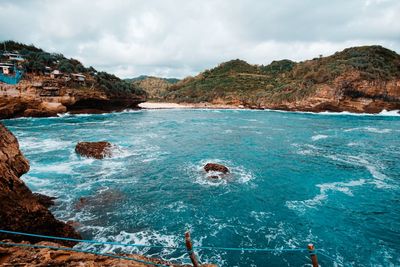 Scenic view of sea and mountains against sky