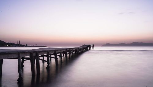 Pier over sea against sky during sunset