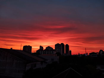 Silhouette buildings against sky during sunset