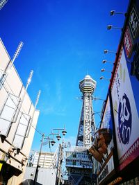 Low angle view of communications tower against blue sky