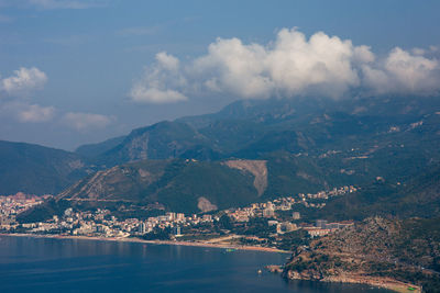 Aerial view of townscape by sea against sky