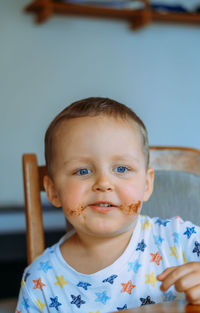 Little cute boy eating bread with chocolate butter