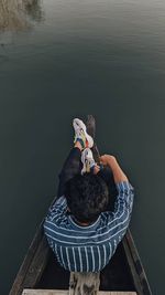 High angle view of boy sitting on boat in river