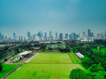 Aerial view of buildings in city against blue sky