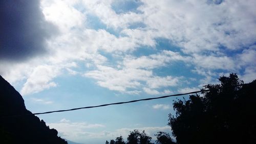 Low angle view of silhouette trees against sky