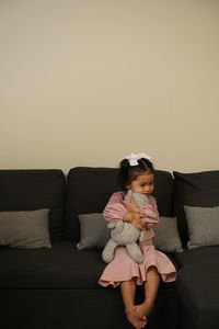 Girl sitting on sofa at home