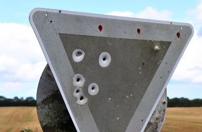 Close-up of smiley face on field against sky