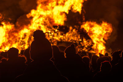 Rear view of people looking fire at night