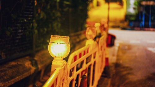 Close-up of illuminated lighting equipment on street at night