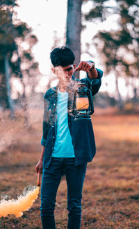 Full length of man photographing on field