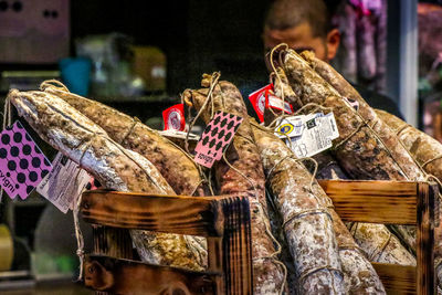 A man examines a basket full of various italian salami specialties at the market in florence