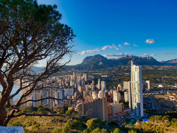 View of buildings in city against blue sky