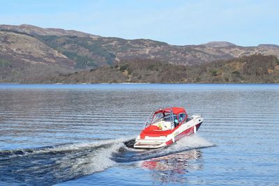 Motorboat in lake against sky