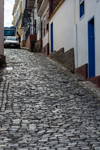 Surface level of cobblestone street amidst buildings