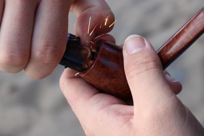 Cropped hand igniting cigar