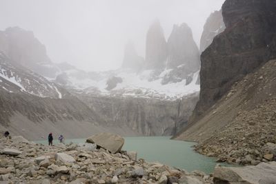 People on rocks by mountains