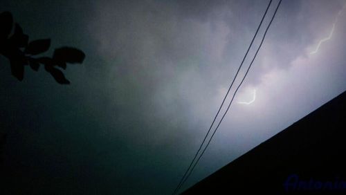 Low angle view of power lines against sky