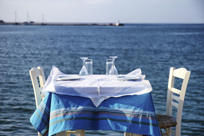 Lounge chairs by sea against blue sky romantic dining 