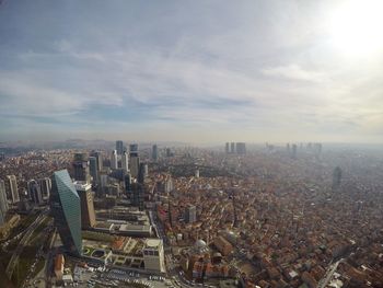 Aerial view of cityscape against cloudy sky