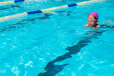 High angle view of girl swimming in pool during sunny day